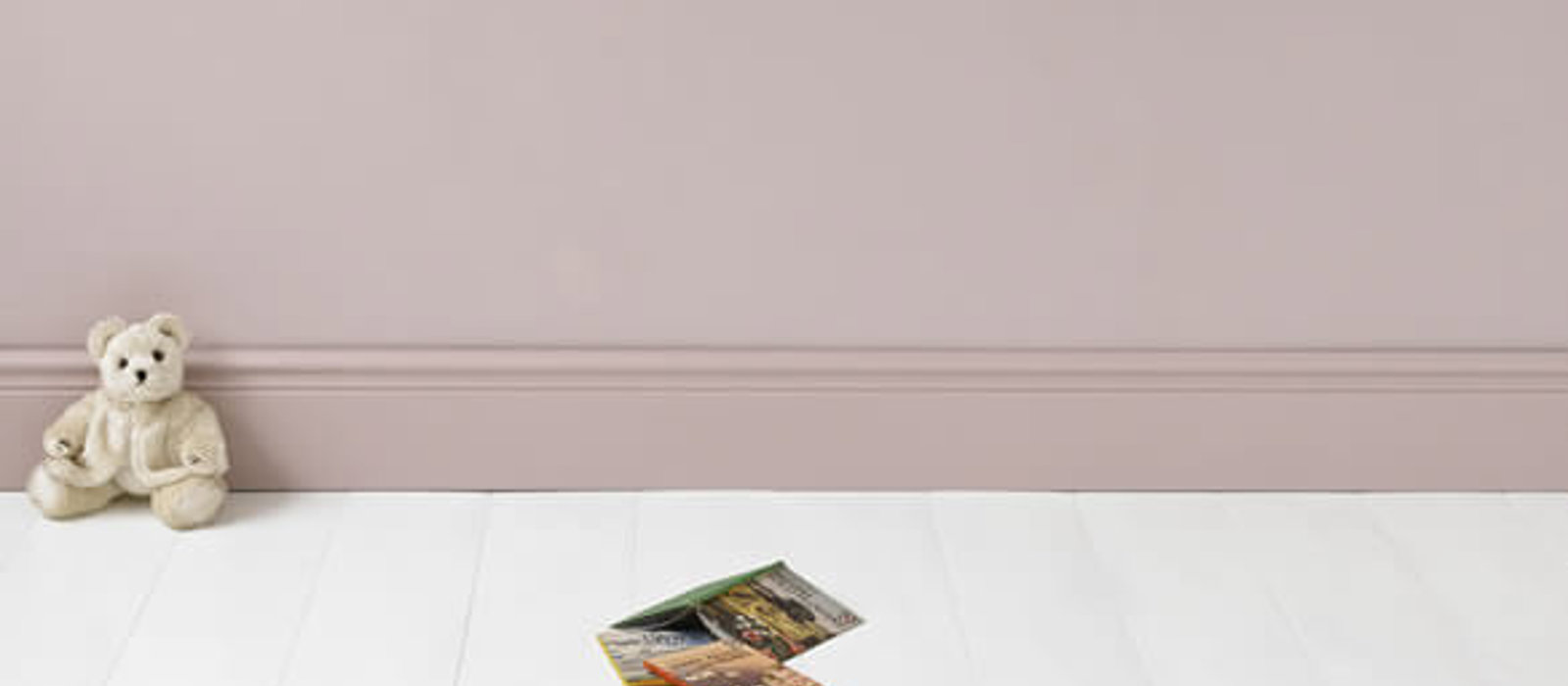 Pink child's room with books and teddy bear on the floor